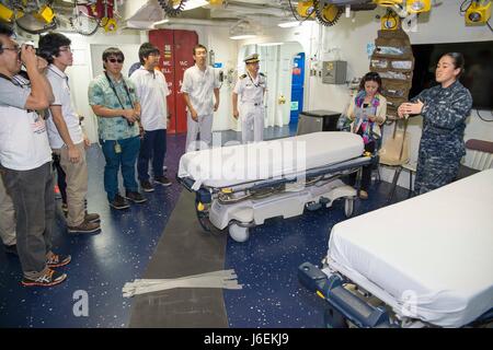 160820-N-XK809-210 OKINAWA, Japan (Aug. 20, 2016) Hospital Corpsman 2nd Class Krystal Miranda guides officers of the Japanese Maritime Self Defense Force (JMSDF) and members of the local community on a tour of the medical department aboard amphibious assault ship USS Bonhomme Richard (LHD 6). The tour provided community members an opportunity to see Bonhomme Richard and learn about the U.S. Navy. Bonhomme Richard, flagship of the Bonhomme Richard Expeditionary Strike Group, is operating in the U.S. 7th Fleet area of operations in support of security and stability in the Indo-Asia-Pacific regio Stock Photo