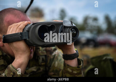 A Soldier with the 1st Battalion, 10th Special Forces Group, uses a laser rangefinder at the Eglin Range, Eglin Air Force Base, Fla., March 17, 2017. Soldiers use the laser rangefinder to identify target location distance, day or night, and with limited visibility such as fog or smoke. (U.S. Air Force photo by Airman 1st Class Joseph Pick) Stock Photo