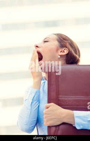 Its is too early for this meeting. Closeup portrait sleepy young business woman, running to work wide open mouth yawning, eyes closed looking bored is Stock Photo