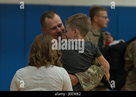 A family embraces during a deployment homecoming May 4, 2017 at Andersen Air Force Base, Guam. Ninetytwo Airmen from the 554th RED HORSE Squadron and two Airmen from the 36th Civil Engineer Squadron, deployed to Southwest Asia September 2016, to provide heavy construction capability in the region. (U.S. Air Force Photo by Airman 1st Class Jacob Skovo) Stock Photo