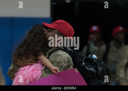 A family embraces during a deployment homecoming May 4, 2017 at Andersen Air Force Base, Guam. Ninetytwo Airmen from the 554th RED HORSE Squadron and two Airmen from the 36th Civil Engineer Squadron, deployed to Southwest Asia September 2016, to provide heavy construction capability in the region. (U.S. Air Force Photo by Airman 1st Class Jacob Skovo) Stock Photo