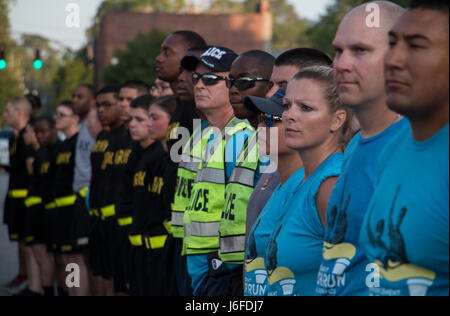 Local law enforcement of Hinesville, Ga. and military police of Fort Stewart stand in formation following a torch run from Stewart into downtown Hinesville, Ga., May 12, 2017 to benefit the state’s Special Olympics Summer Games. Representatives of the Georgia State Patrol, Hinesville Police Department, Liberty County Sherriff’s office and local Alcohol, Tobacco and Firearms office completed the two-mile run alongside Soldiers of 385th Military Police Battalion, 16th Military Police Brigade. (U.S. Army photo by Staff Sgt. Candace Mundt/Released) Stock Photo
