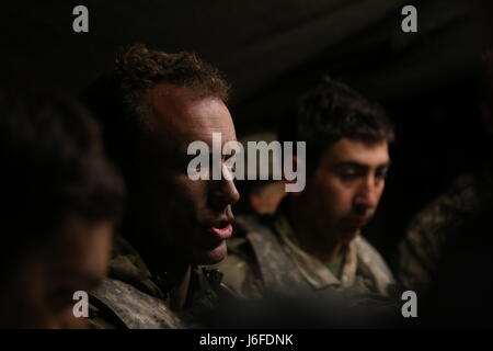 British Army Lt. Col. Nick Cowley of the Queens Royal Hussars briefs his soldiers for an upcoming mission while conducting tactical operations during Saber Junction 17 at the Hohenfels Training Area, Germany, May 12, 2017. Saber Junction 17 is the U.S. Army Europe’s 2nd Cavalry Regiment’s combat training center certification exercise, taking place at the Joint Multinational Readiness Center in Hohenfels, Germany, Apr. 25-May 19, 2017. The exercise is designed to assess the readiness of the regiment to conduct unified land operations, with a particular emphasis on rehearsing the transition from Stock Photo