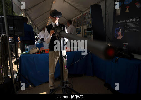A student participates in a Department of Defense Lab Day demonstration at the Pentagon, experiencing a virtual reality simulation of firing a Navy machine gun to support training and educational outreach. Stock Photo