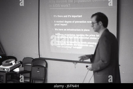 A man delivers a speech in front of a presentation screen during a professional or military event, illustrating communication, instruction, and audience engagement. Stock Photo