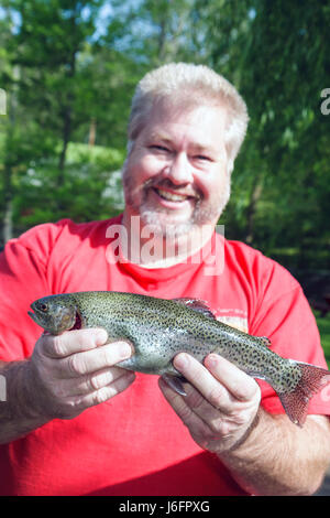 Sevierville Tennessee,Smoky Mountains,English Mountain Trout Farm & Grill,catch,eat,rainbow trout,fishing,man men male adult adults,holds,smile,smilin Stock Photo