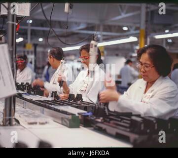 Fremont, California, USA. 15th July, 1998. Business, Solectron, Factories. Female workers on assembly line. Silicon Valley factories sub-contract manufacturing parts for computers, pagers, printers and electronics. Credit: Mark Richards/ZUMA Wire/ZUMAPRESS.com/Alamy Live News Stock Photo