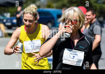 Saku, Estonia. 20th May, 2017. Participants drink beer during the Beer Mile Run in Saku, Estonia, May 20, 2017. Participants must run four laps for a total of one mile distance and start each lap by drinking a can of beer. Credit: Sergei Stepanov/Xinhua/Alamy Live News Stock Photo
