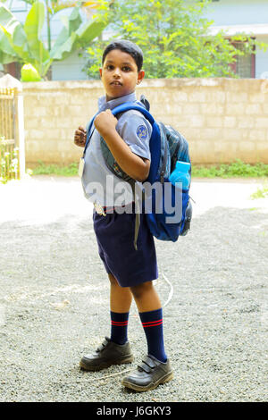 indian school kid ready to go school wearing uniform and school bag,thrissur,kerala,south india,asia,child in school uniform,PRADEEP SUBRAMANIAN Stock Photo