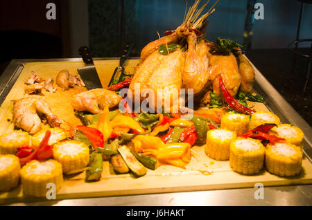 Roasted Chicken and fried bell peper serve with grilled corn at food buffet service for people serve in restaurant of Hotel in Thailand Stock Photo