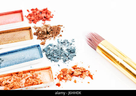 Brush and multicolor crushed crack eyeshadows on white background Stock Photo