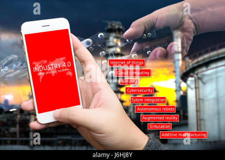 Industrial 4.0 concept image, Cyber Physical Systems concept , Man holding smart phone screen with industry4.0 text. Robot and human holding hands wit Stock Photo