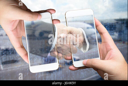 Two Businessman hands holding smartphones. Man suit holding hand with handshake with airport binary coded background. Fintech , business concept Stock Photo