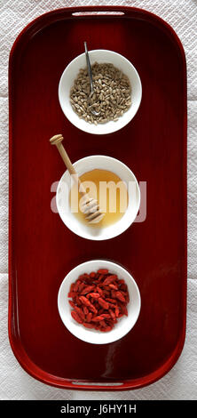 Sample of healthy foods in white bowls on a red tray. Stock Photo