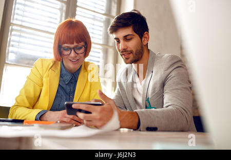 designer meeting -colleagues discussion, talking and sharing ideas on smart phone Stock Photo