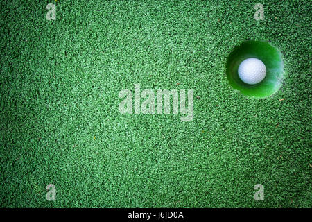 Mini golf scene with ball and hole. Can be used like background. Sunny day at resort park Stock Photo