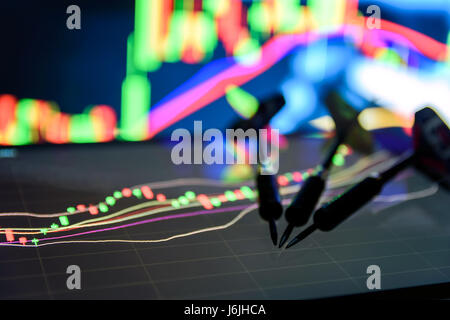 Selective focus on end of Three arrows dart on tablet screen with stock market graph and abstract blur graph background , Plan to select stock idea co Stock Photo
