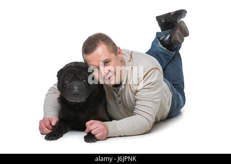 Handsome man hugging black shar pei dog. Studio shot isolated on white background. Copy space. Stock Photo