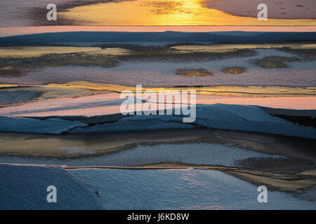 Ice texture of a frozen river in the winter in the sun at sunset Stock Photo