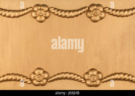 Luxury frame made of golden stucco plaster lying on gold surface, with space for your text Stock Photo