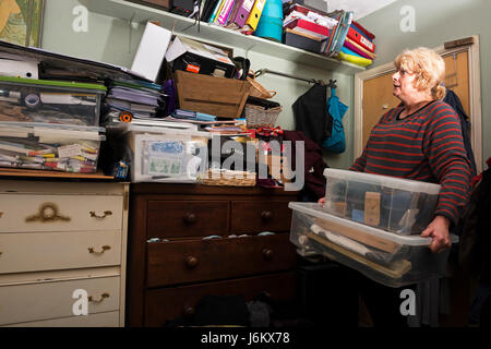 Woman in her bedroom which is full of clutter Stock Photo