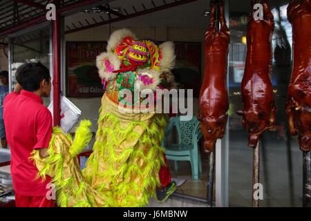 Quezon City, Philippines. 21st May, 2017. Children perform a dragon dance at a lechon (roasted pig) store during the La Loma Lechon festival in Quezon City, east of Manila, Philippines on Sunday, May 21, 2017. The festival, whose main highlight is the parade of lechon dressed in different costumes, is held every third Sunday of May, coincides with the Feast of Nuestro Señor de Salvacion, and has been a tradition in the area for more than fifty years. Credit: Richard James M. Mendoza/Pacific Press/Alamy Live News Stock Photo