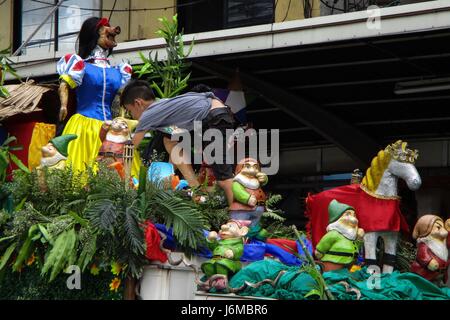 Quezon City, Philippines. 21st May, 2017. A boy climbs on top of a float containing a lechon (roasted pig suckling) during the La Loma Lechon festival in Quezon City, east of Manila, Philippines on Sunday, May 21, 2017. The festival, whose main highlight is the parade of lechon in different costumes, is held every third Sunday of May, coincides with the Feast of Nuestro Señor de Salvacion, and has been a tradition in the area for more than fifty years. Credit: Richard James M. Mendoza/Pacific Press/Alamy Live News Stock Photo