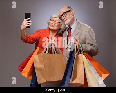 Happy couple taking selfie after shopping with many bags Stock Photo