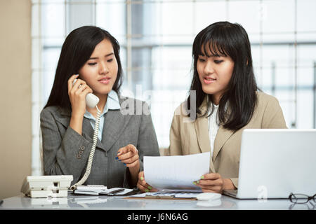 close up image of two businesswomen working and discussing in office Stock Photo