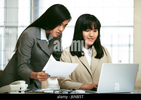 two office staffs working and discussing in office Stock Photo
