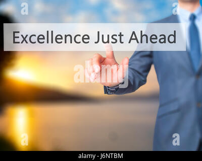 Excellence Just Ahead - Businessman hand pressing button on touch screen interface. Business, technology, internet concept. Stock Photo Stock Photo