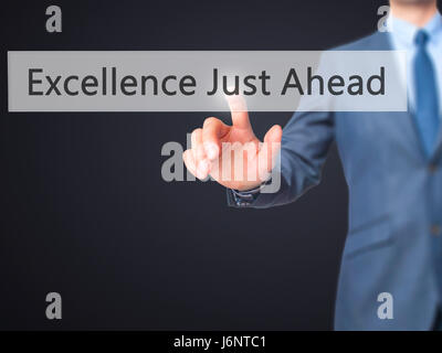 Excellence Just Ahead - Businessman hand pressing button on touch screen interface. Business, technology, internet concept. Stock Photo Stock Photo