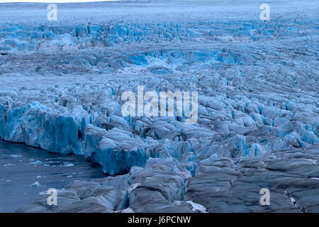 Harsh glaciers of Arctic. Live glacier. Icefall on high rock bar. Novaya Zemlya archipelago, North island. View from helicopter Stock Photo