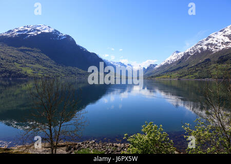 A wonderful beautiful spring day in Loen in Sogn with green trees and snowy mountains. Stock Photo