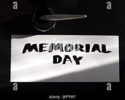 Memorial day calligraphy and lettering post card with inkstand. Top view and sunlight shadow. Stock Photo