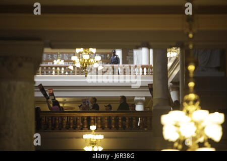 An Indiana State Police trooper watches at a group of protesters stage a New Orleans style funeral parade in the Indiana Statehouse. Stock Photo