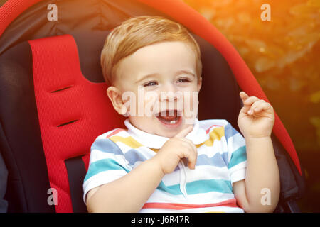 little boy sitting in a stroller Stock Photo