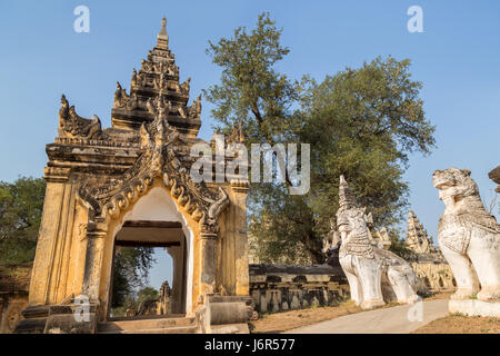 Ornate gate and guardian lion statues at the Maha Aungmye (Aung Mye) Bonzan monastery in Inwa (Ava) near Mandalay in Myanmar (Burma). Stock Photo