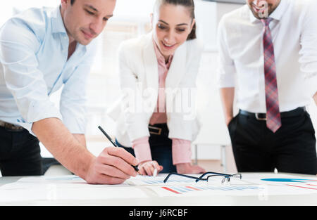 Business people analyzing data - glasses on graph Stock Photo