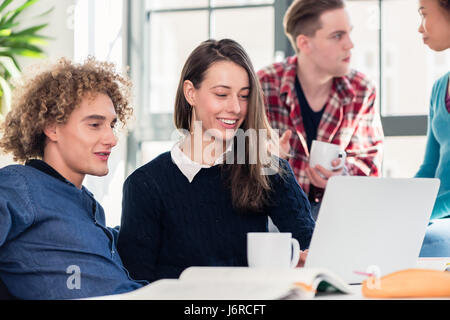 Two young students searching for an answer to their question bot Stock Photo
