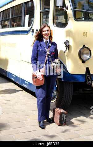 A young woman dresses up as a bus conductor for Haworth's 1940s weekend in Yorkshire. Stock Photo