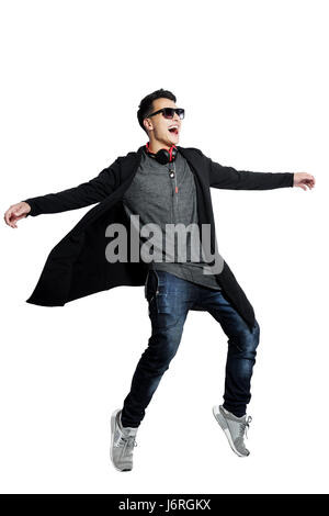 Picture of attractive young man in sunglasses dancing over white background . Stock Photo