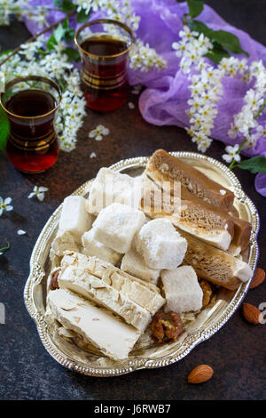 Rahat Lukum, sherbet, halva and tea on the kitchen table. Turkish and Arabic sweets. Ramadan food. Stock Photo