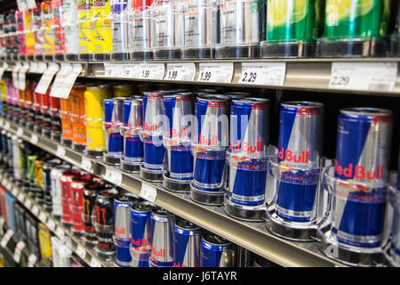 Cans of Red Bull Energy drink on the shelves of a grocery store Stock Photo