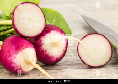 Juicy fresh radish in a cut on a white wooden background close up Stock Photo