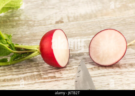 Juicy fresh radish in a cut on a white wooden background close up Stock Photo