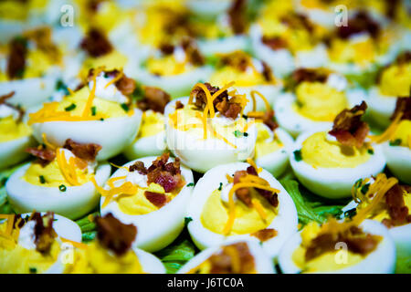 Close up of deviled eggs, bacon, cheese and garnish. Great colors and looks delicious. Stock Photo