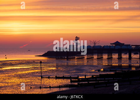 Herne Bay, Kent, UK. 22nd May 2017: UK Weather. Pre sunrise glow at Herne Bay pier as contrails out at sea can be seen, caught in the early morning light at low tide. The coming week is set to see the highest temperatures this year with 27C predicted, and people are expected to head to the seaside helter skelter and amusements on Herne Bay seafront. Credit: Alan Payton/Alamy Live News Stock Photo