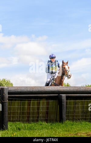 Rockingham Castle, Corby, UK. 21st May, 2017. Riding Big Class Affair, Zara Tindall (granddaughter of Queen Elizabeth II of the United Kingdom) clears a fence on a sunny day during the cross country phase of the Rockingham International Horse Trials in the grounds of the Norman castle at Rockingham, Corby, England on 21st May 2017. Credit: miscellany/Alamy Live News Stock Photo