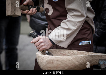 Man's hands of the joiner do a bowl, beats a hammer on a chisel Stock Photo